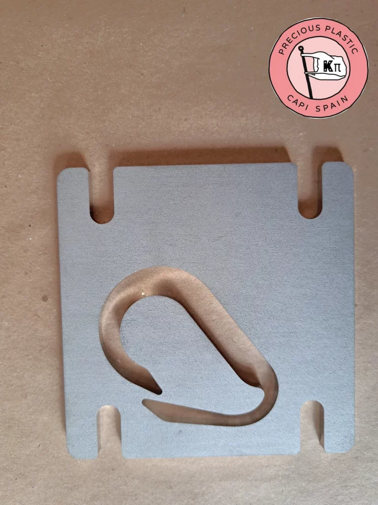 Stainless steel mini injection mould plate with a carabiner shape, from Precious Plastic Capi Spain's Mini Injection Moulds Series.