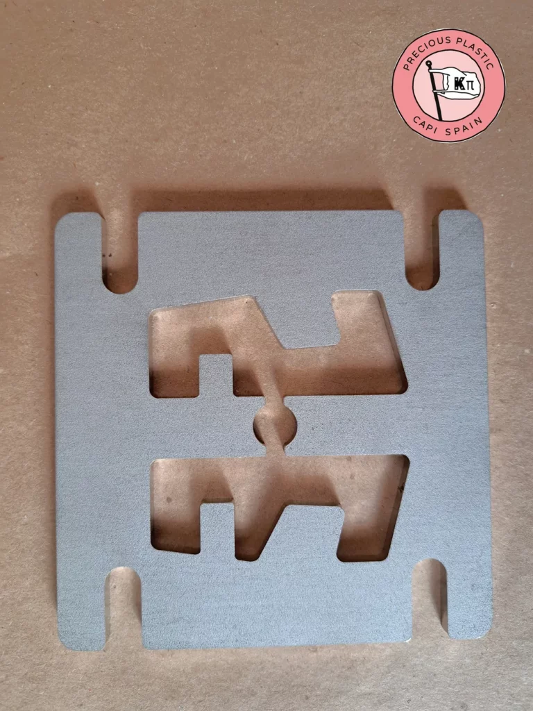 Stainless steel mini injection mould plate with a support shape, from Precious Plastic Capi Spain's Mini Injection Moulds Series.