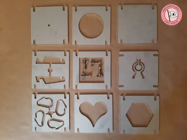 Set of nine modular injection mould plates with geometric and symbolic cut‑outs made by Precious Plastic Capi Spain.