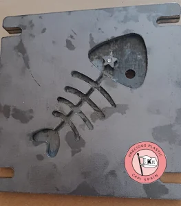 Placa base de acero mecanizada en relieve con la silueta de un logotipo de espina de pescado para molde de inyección 2D.