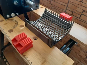 Close-up view of the removable tray with the curved carbon steel perforated sieve for the Precious Plastic V2.1 shredder.