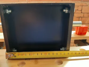 Mesure de la largeur du panneau latéral du bloc assemblé du broyeur Precious Plastic V2.1 à l'aide d'un mètre ruban.