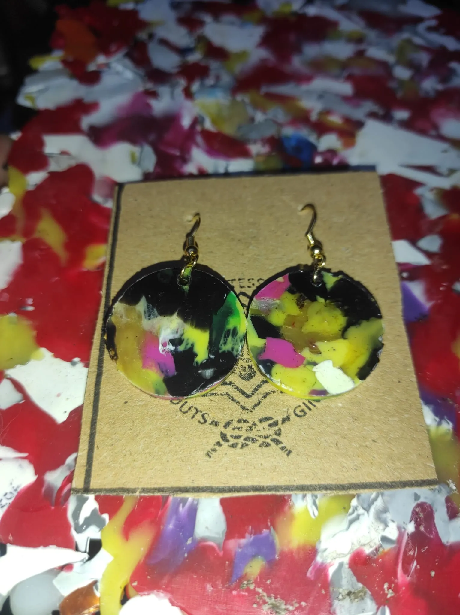 Pendientes artesanales circulares de plástico reciclado con patrón veteado multicolor, creados a partir de láminas del molde A4.